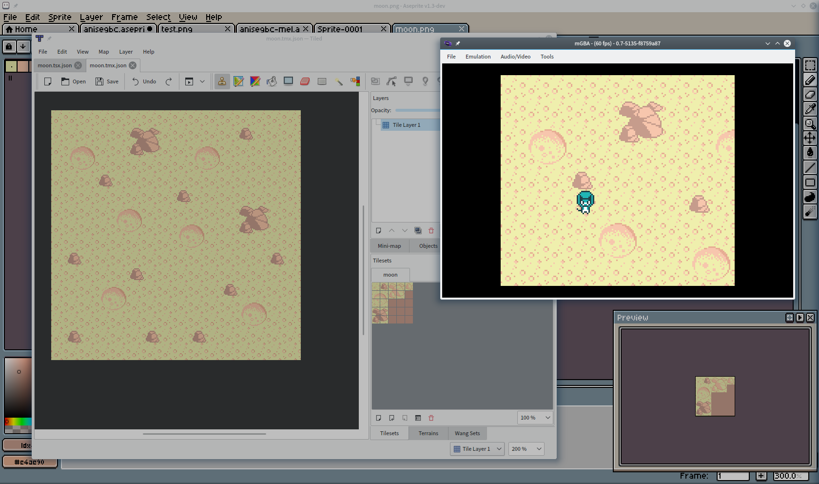 My desktop, showing the moon tiles in an image editor, the map put together in Tiled, and the game running in mGBA